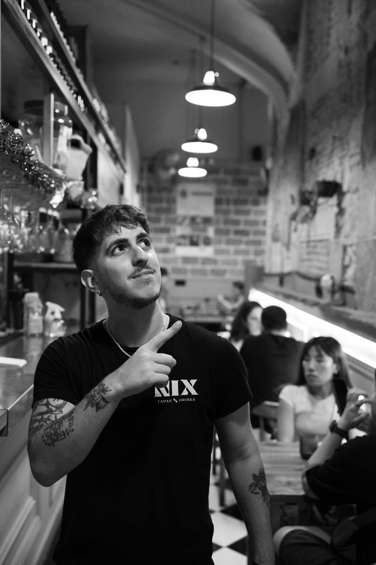 Nix team member in a NIX Tapas & Drinks t-shirt inside the bar