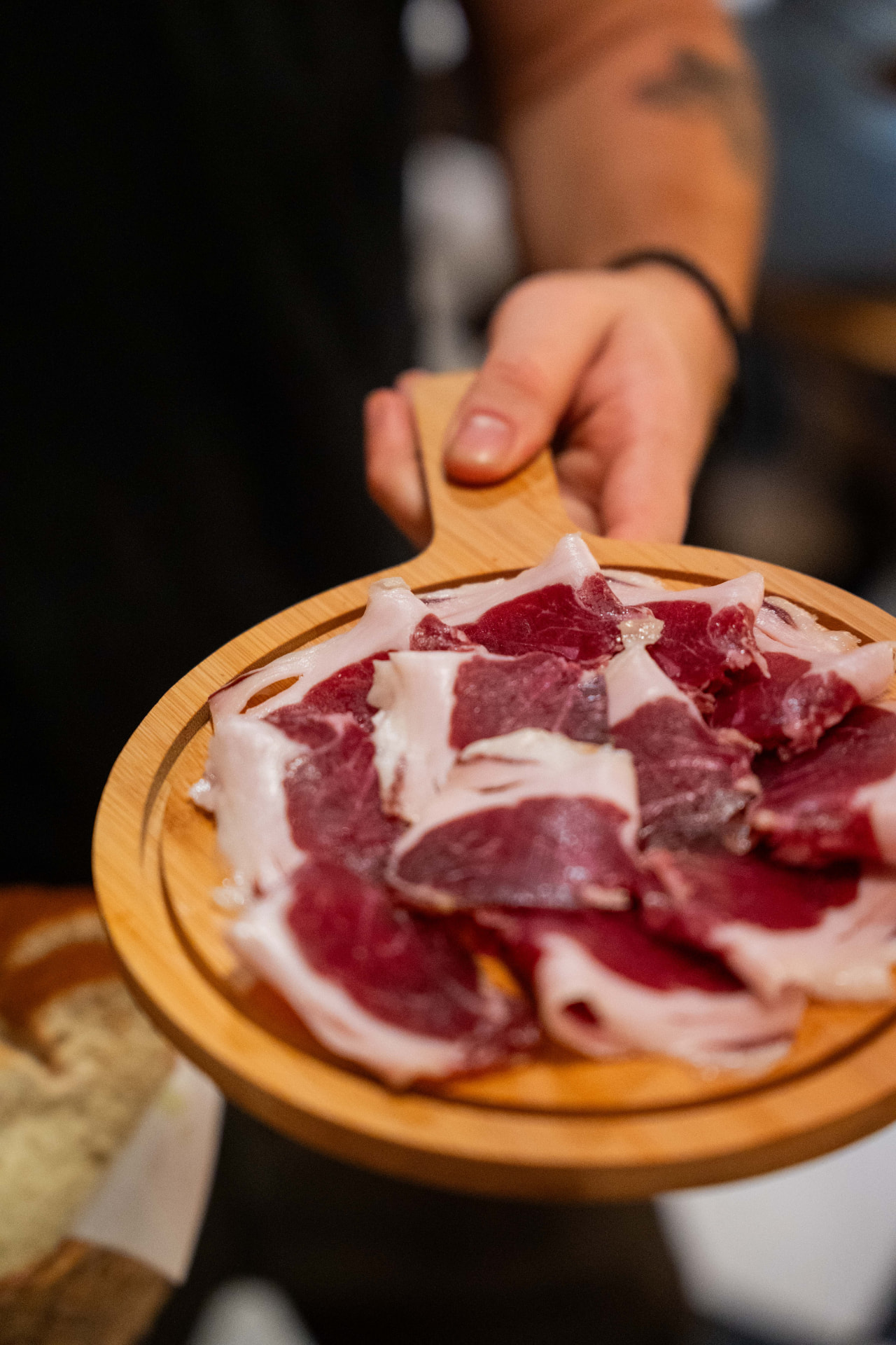 Wooden board with thin slices of cured Iberian ham